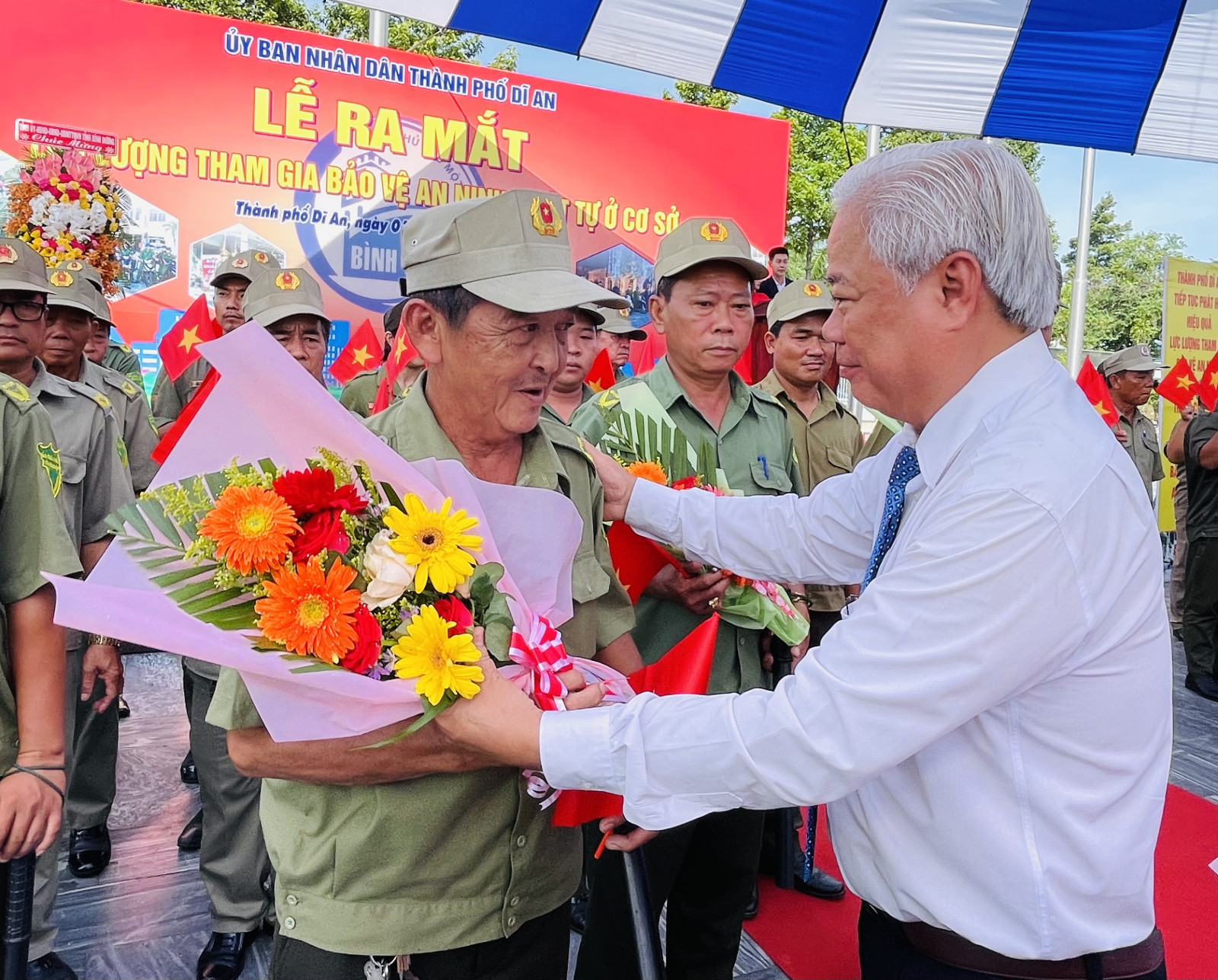 Đồng chí Hồ Quang Điệp tặng hoa cho đại diện lực lượng tham gia bảo vệ ANTT ở cơ sở TP. Dĩ An.
